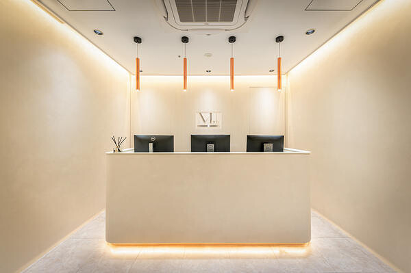 大阪市の美容クリニックの受付カウンターと間接照明の内装