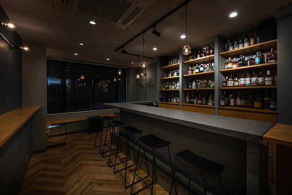 銀座の落ち着いたバーのカウンターとバックバーの内装